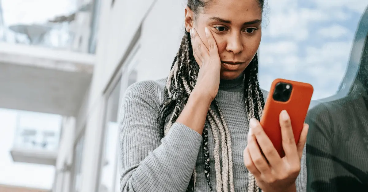 Concerned woman looking at their phone, representing worry about the long-term impact of a DUI on their public record