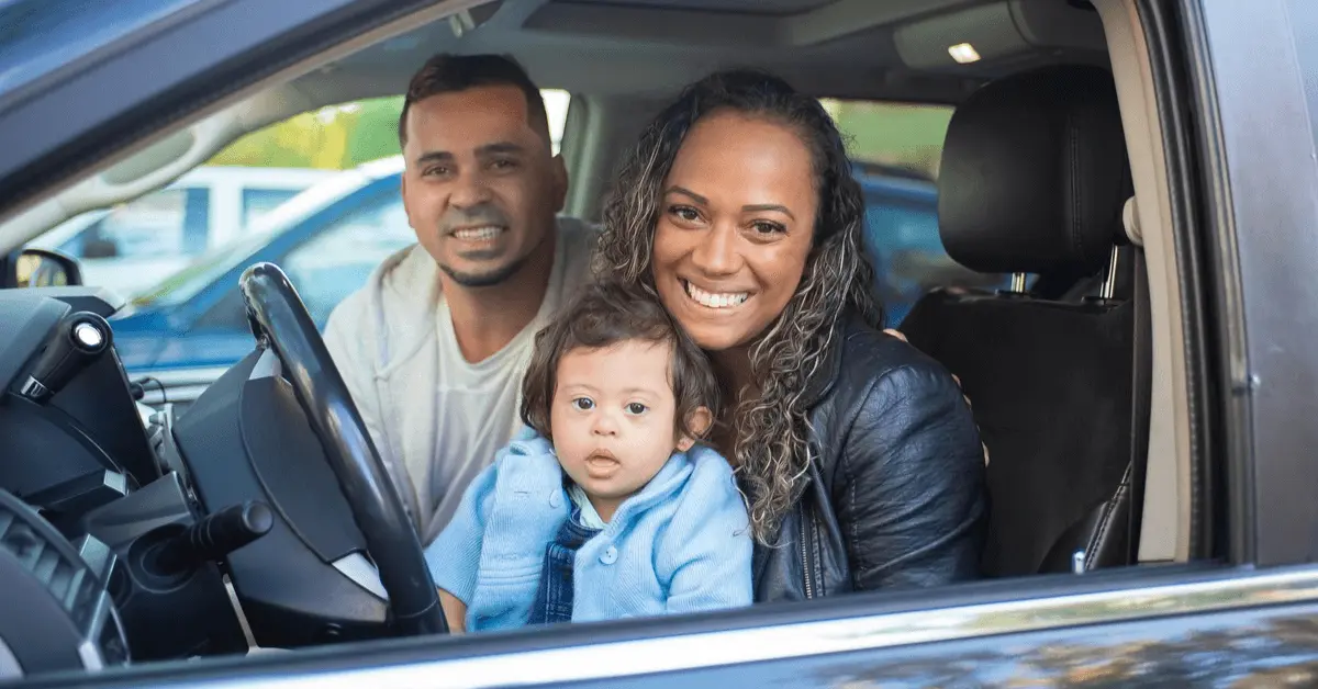 Smiling family sitting inside a car after regaining driving privileges following a DUI