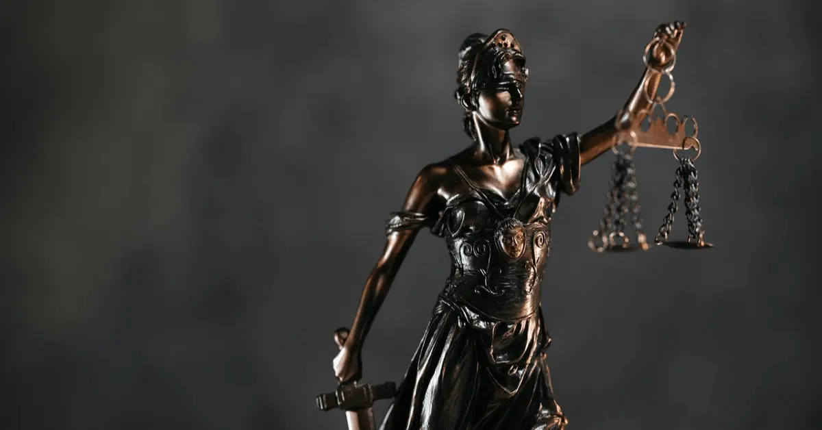 Bronze statue of Lady Justice holding scales and a sword, symbolizing fairness and the judicial system