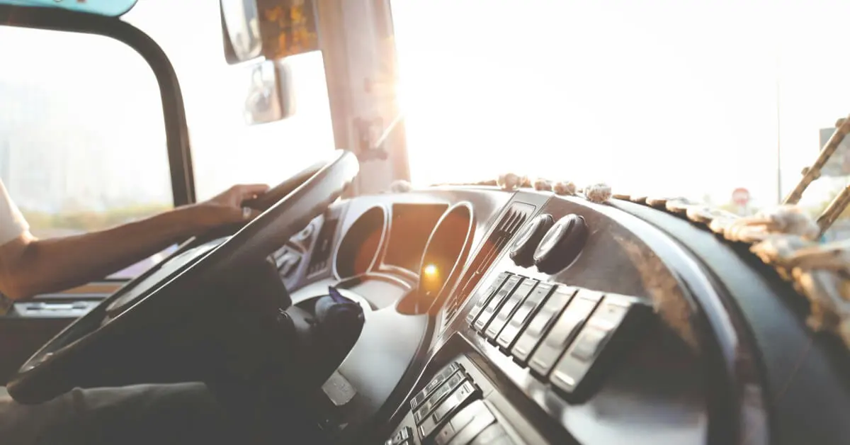 Close-up of a commercial truck driver's hands on the steering wheel