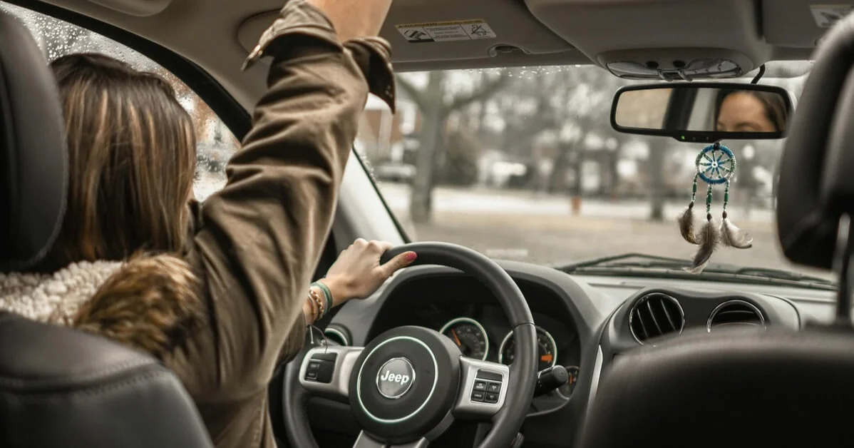 Driver confidently behind the wheel of a Jeep, symbolizing freedom and a fresh start after having their driving record expunged