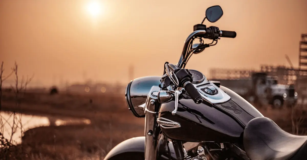 Close-up of a parked motorcycle at sunset