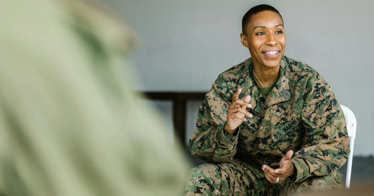 Smiling U.S. Marine in uniform engaging in conversation