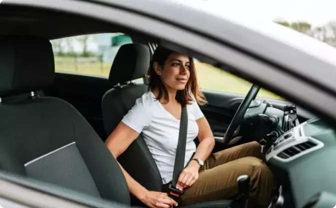Woman buckling her seatbelt in the driver’s seat
